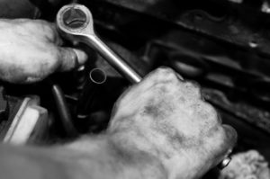 Hands using wrench on engine